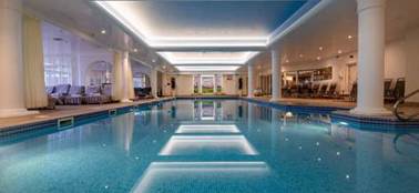 A indoor swimming pool with columns and lights

AI-generated content may be incorrect.